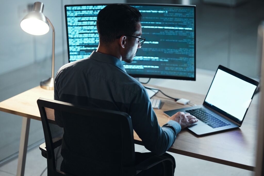 Man, night and coding in office, computer or blank screen for mockup space with html, programming o